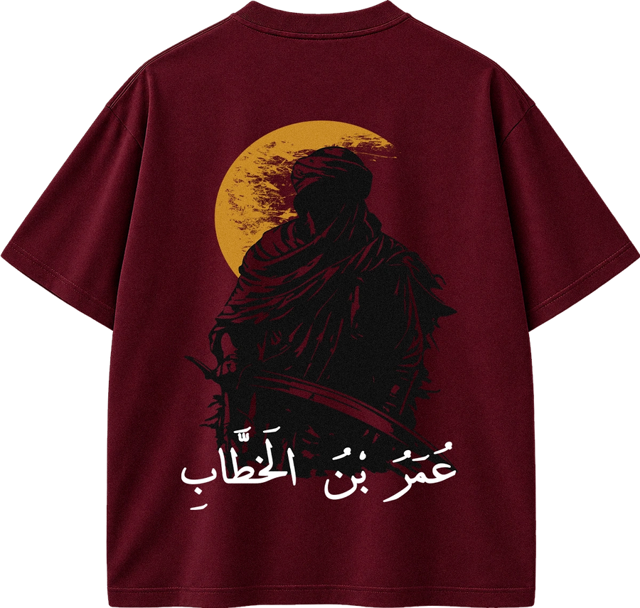 A maroon short-sleeve t-shirt shown from the back, featuring a graphic print of a robed figure silhouette against a yellow moon, with white Arabic text below.