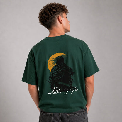 Person wearing a green t-shirt with a graphic design on the back against a gray background