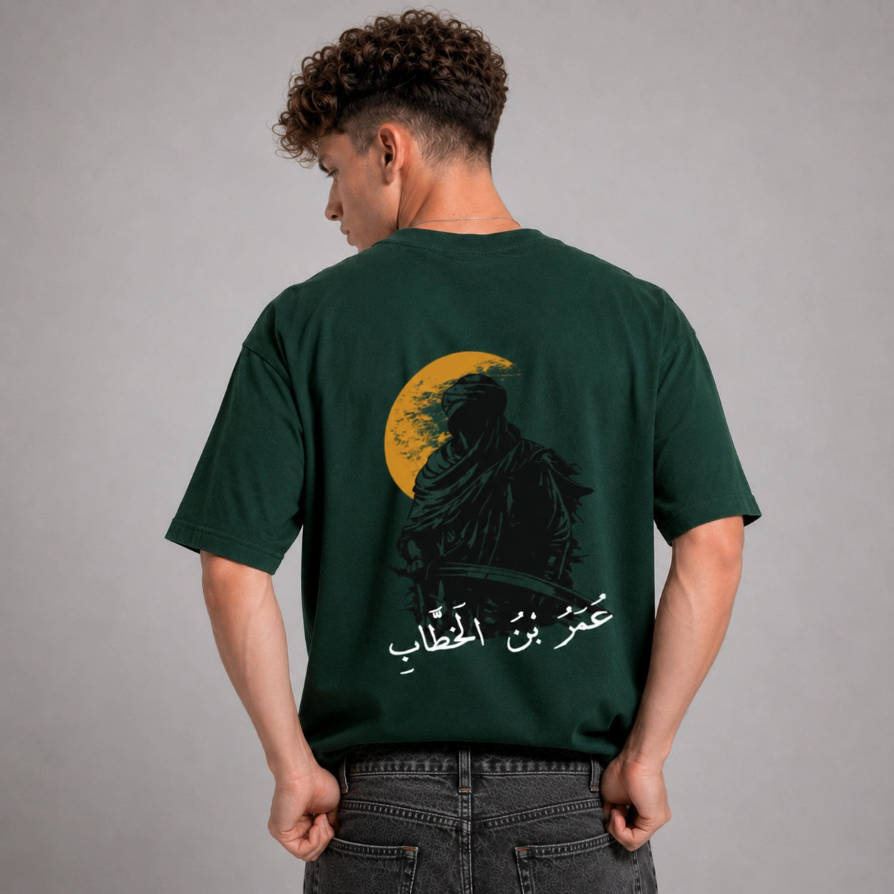 Person wearing a green t-shirt with a graphic design on the back against a gray background