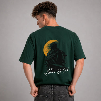 Person wearing a green t-shirt with a graphic design on the back against a gray background