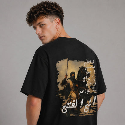 Man wearing a black t-shirt with a graphic design on the back against a gray background