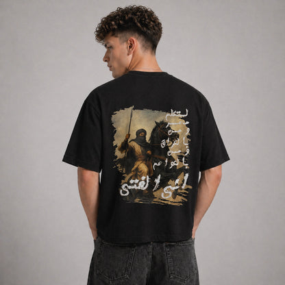 Person wearing a black t-shirt with a graphic design on the back against a gray background