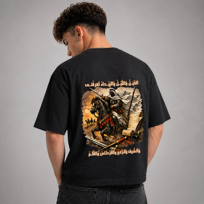 Person wearing a black t-shirt with a graphic design on the back against a gray background