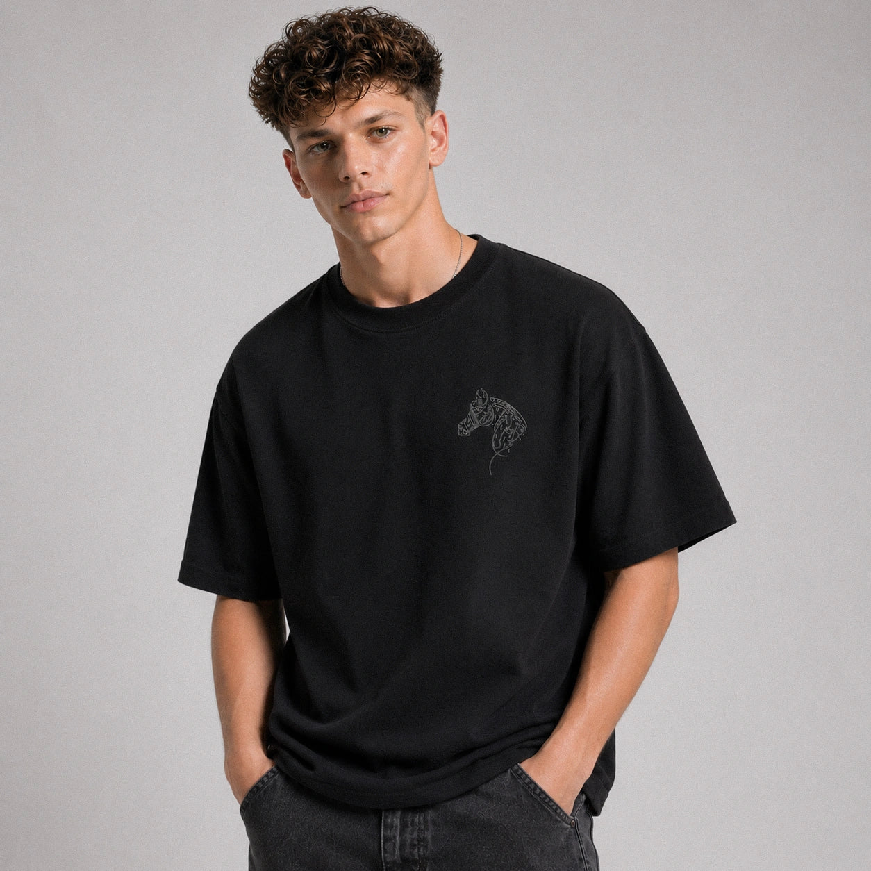 Person wearing a black t-shirt with a graphic design on a gray background