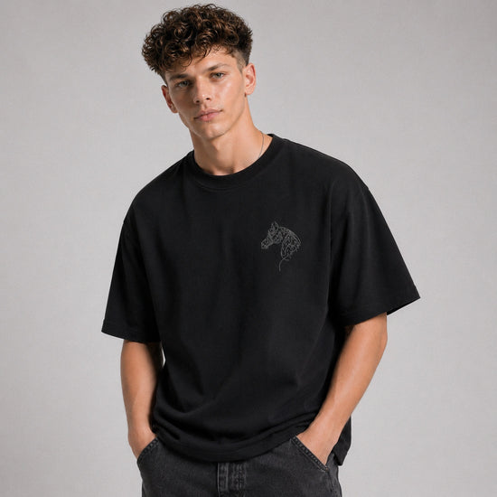 Person wearing a black t-shirt with a graphic design on a gray background