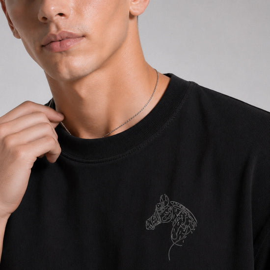 Person wearing a black sweatshirt with a horse design on a gray background