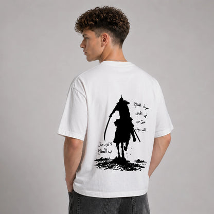 Person wearing a white t-shirt with a black graphic design on the back against a gray background