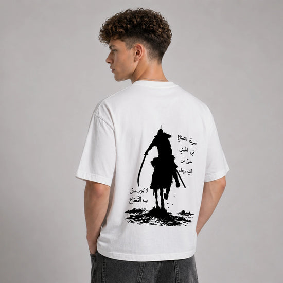 Person wearing a white t-shirt with a black graphic design on the back against a gray background