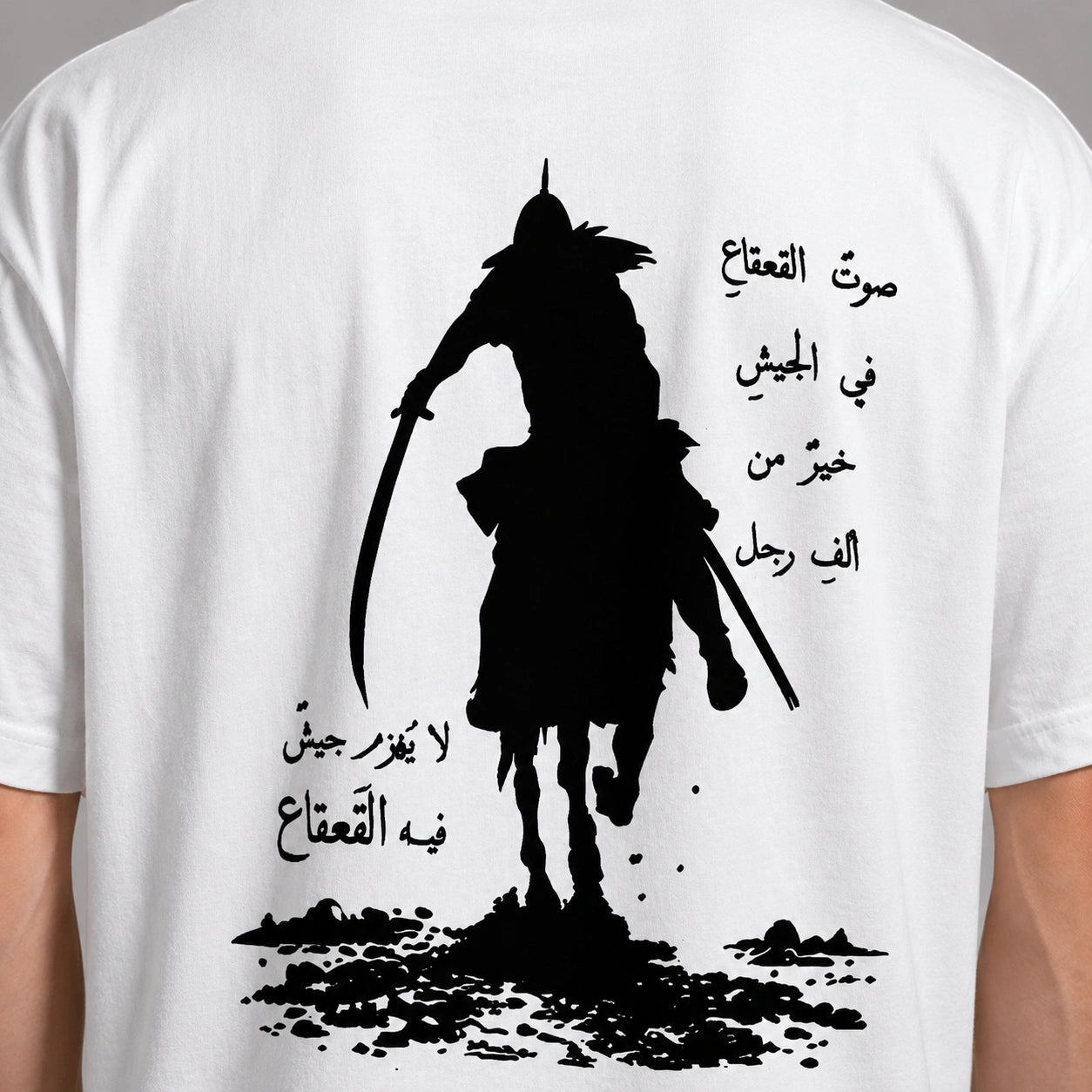 White t-shirt with black graphic of a warrior on horseback and Arabic text.