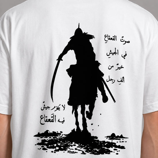 White t-shirt with black graphic of a warrior on horseback and Arabic text.
