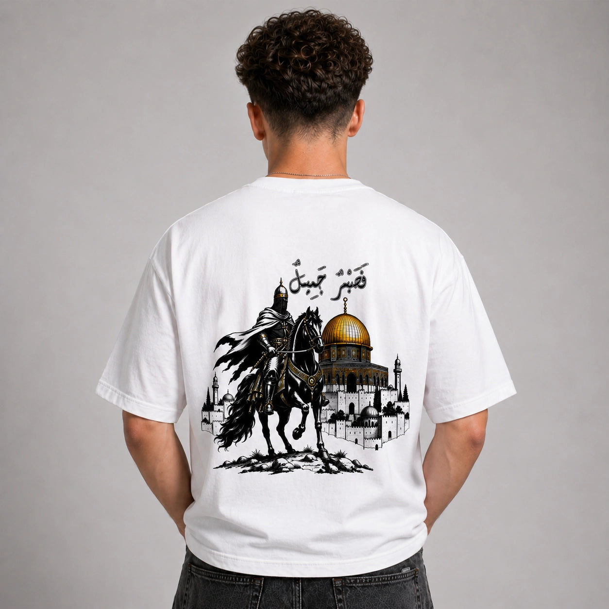 Person wearing a white t-shirt with a graphic design on the back, featuring a horse and a dome.