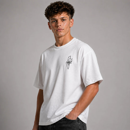Person wearing a white t-shirt with a small graphic on a gray background