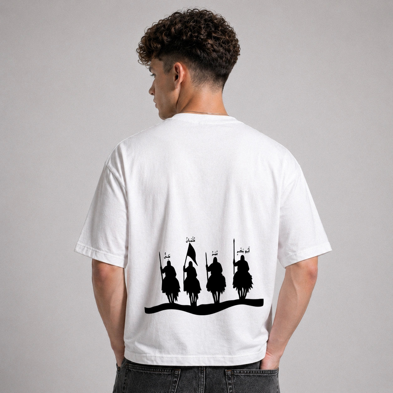 Person wearing a white t-shirt with black graphic design on the back against a gray background