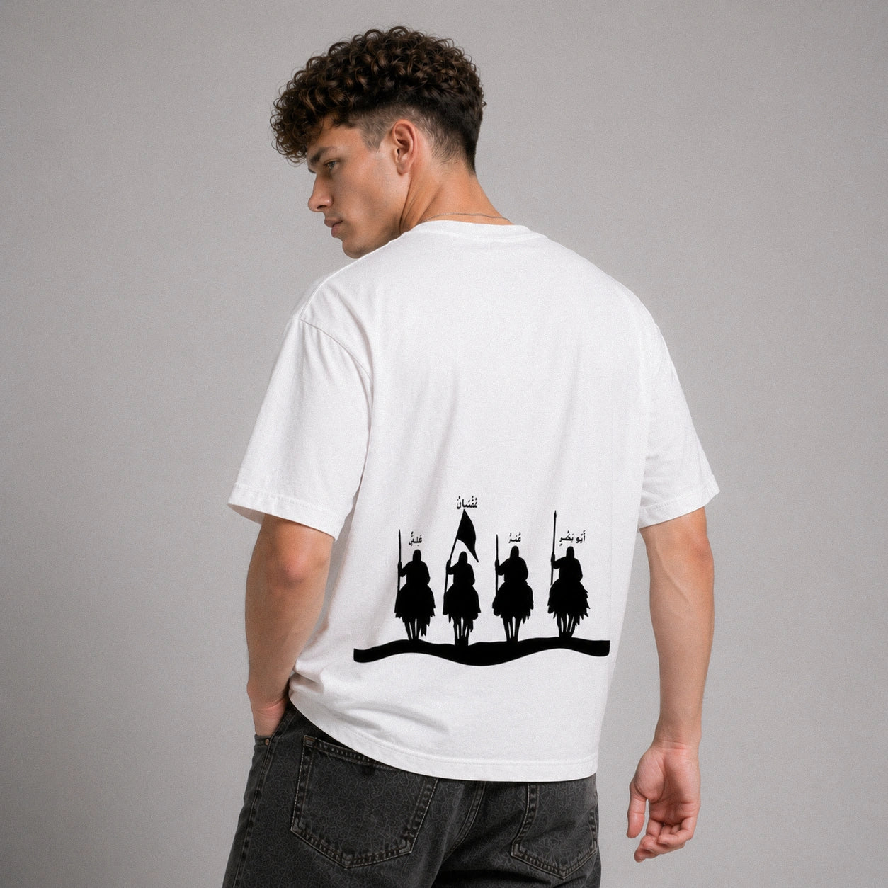 Person wearing a white t-shirt with black graphic design on the back against a gray background