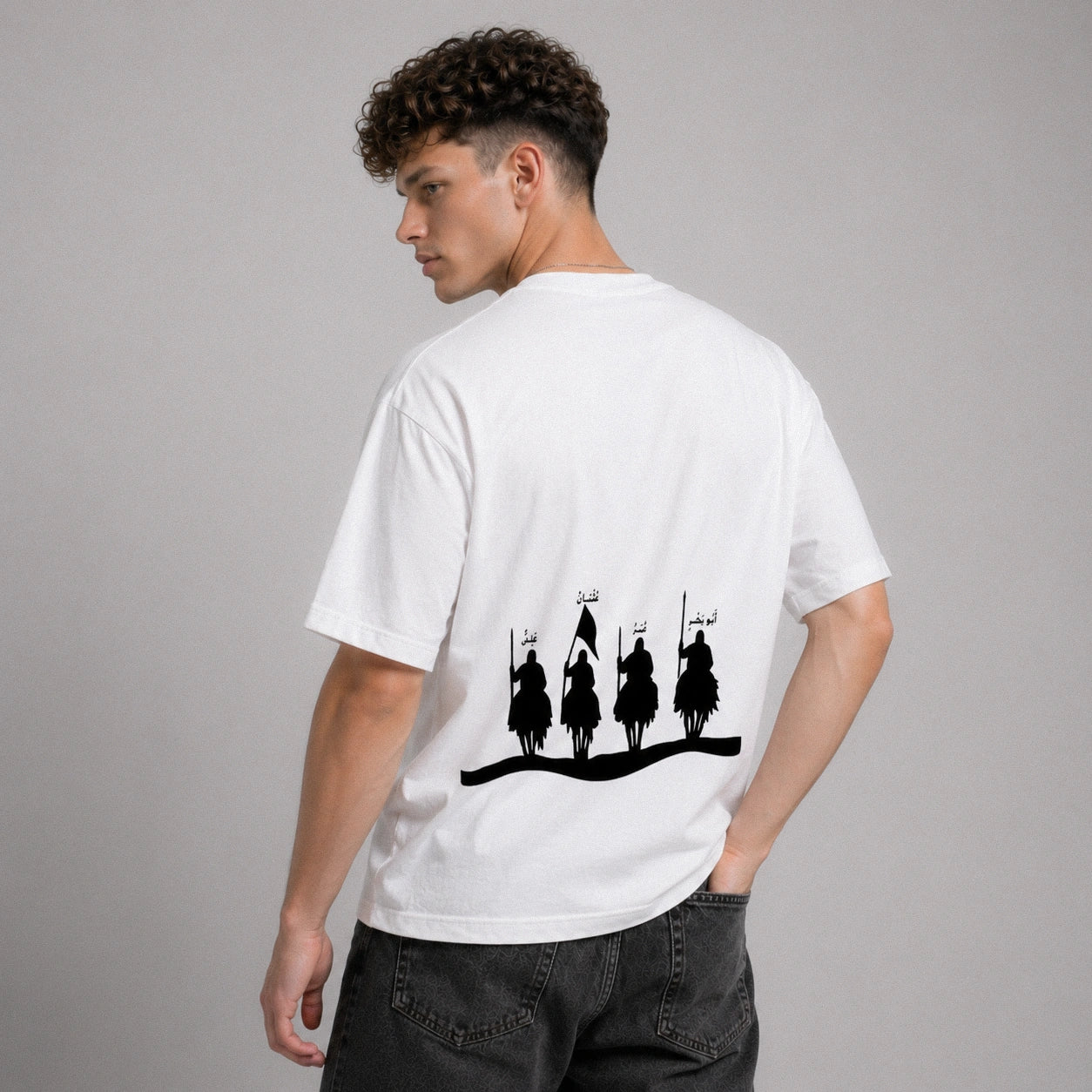 Person wearing a white t-shirt with black graphic design on the back, standing against a gray background