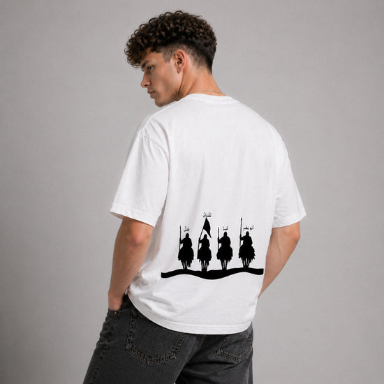 Person wearing a white t-shirt with black graphic design on the back, standing against a gray background