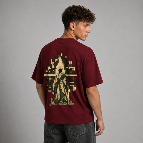 A man wearing a maroon t-shirt with a large graphic print on the back, shown from behind against a neutral gray studio background.