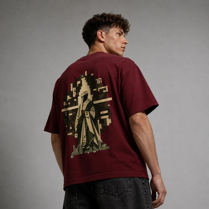 A man wearing a maroon t-shirt with a large beige graphic print on the back, shown from behind against a gray studio background.