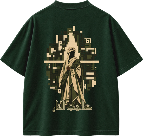 A dark forest green short-sleeve t-shirt shown from the back, featuring a large graphic print of a pixelated figure in beige and olive green robes with Arabic calligraphy below.