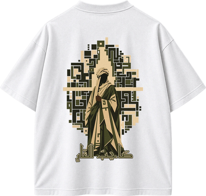 White short-sleeve T-shirt shown from the back, featuring a large graphic print of a robed figure with Arabic text and a geometric pattern in beige, olive green, and black.
