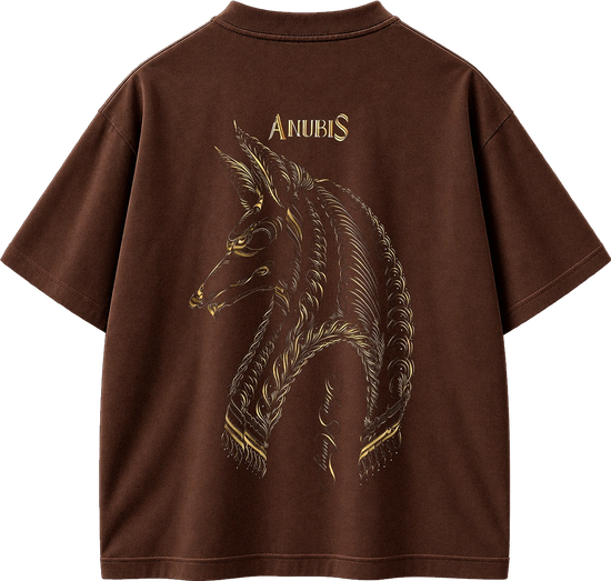 A brown short-sleeve t-shirt shown from the back, featuring a large gold-toned graphic of a horned animal head with the word 'ANUBIS' printed above it.