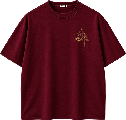 A dark burgundy short-sleeve t-shirt with a small gold Egyptian eye and pyramid graphic on the left chest, displayed on a clean white background.