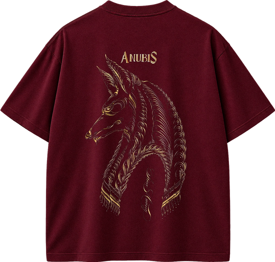 A maroon short-sleeve t-shirt shown from the back, featuring a large gold-toned graphic of the Anubis horse head with the word 'ANUBIS' printed above it.