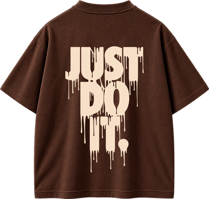 A brown short-sleeve t-shirt shown from the back, featuring a large cream-colored dripping text graphic that reads 'JUST DO IT.' on the back.