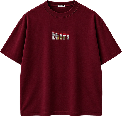A dark red short-sleeve crewneck t-shirt with a small chest graphic featuring the word 'REVIVAL' in a distressed, layered red, white, and gold design. The shirt is displayed flat against a solid white background.