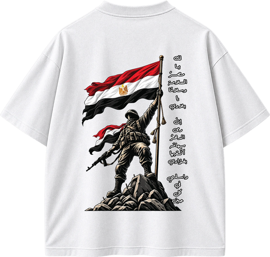 White short-sleeve t-shirt showing the back graphic print. The design features a soldier standing on rocks holding the Egyptian flag, with Arabic calligraphy printed vertically alongside.