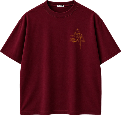 A dark burgundy short-sleeve t-shirt with a small gold Egyptian eye and pyramid graphic on the left chest, displayed on a clean white background.