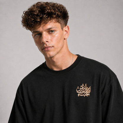 Man wearing a black sweatshirt with gold text on a gray background