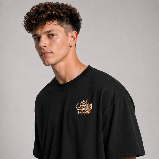 Man wearing a black t-shirt with gold text on a gray background
