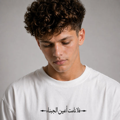 Man wearing a black t-shirt with Arabic text on a gray background
