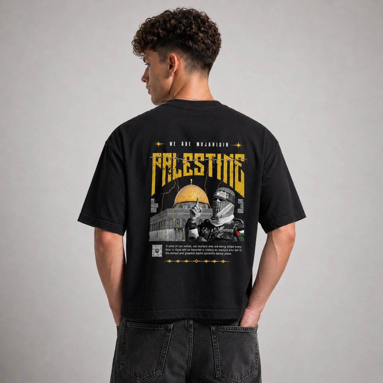 Person wearing a black t-shirt with a graphic design on the back, featuring text and images.