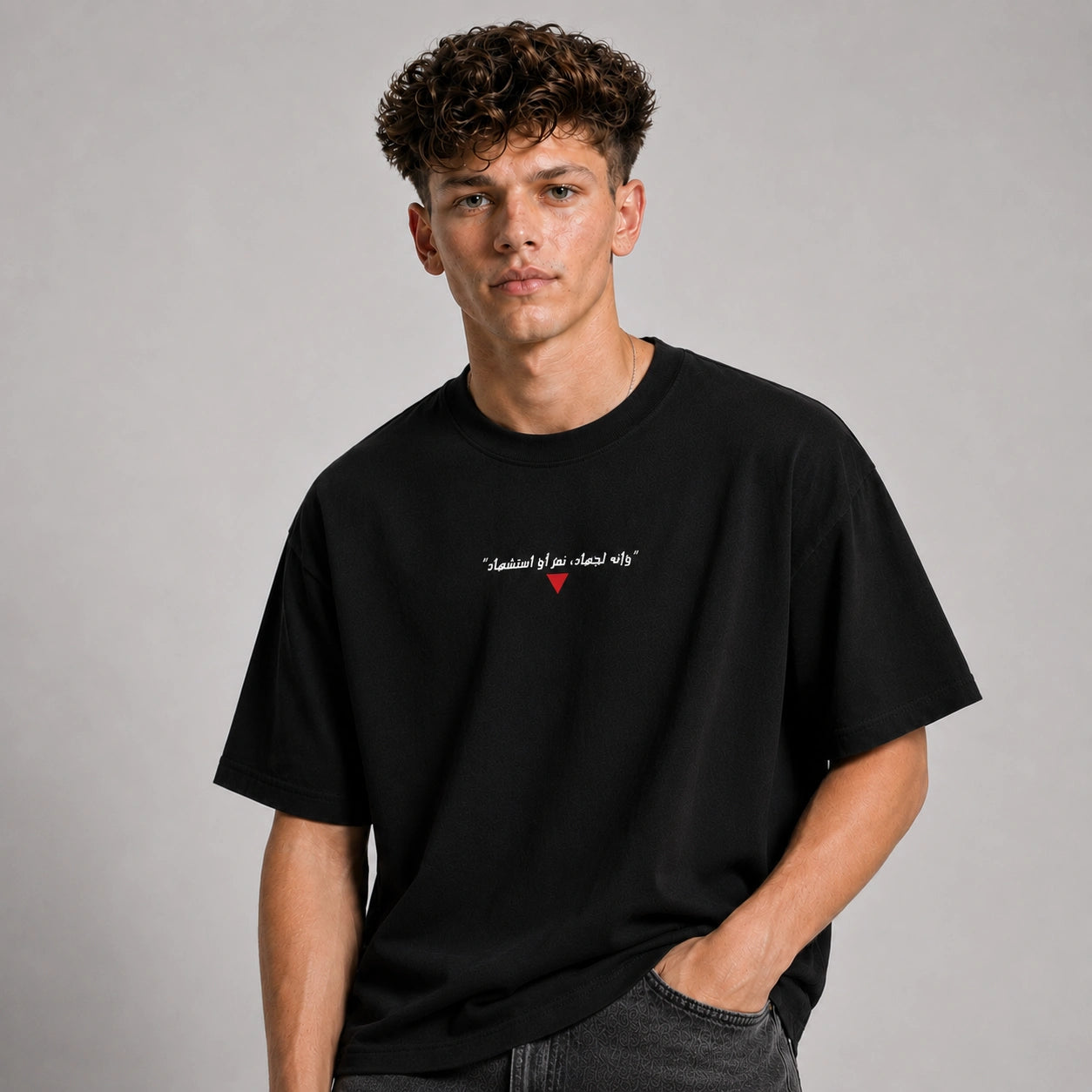 Man wearing a black t-shirt with text and a red heart symbol on a gray background