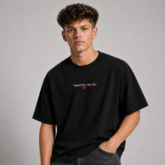Man wearing a black t-shirt with text and a red heart symbol on a gray background