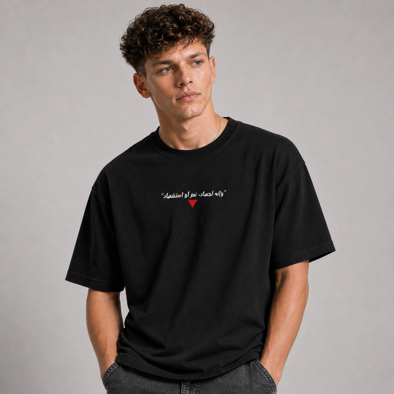 Man wearing a black t-shirt with text and a red heart on a gray background