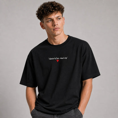 Man wearing a black t-shirt with text and a red heart on a gray background