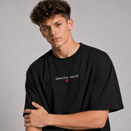 Person wearing a black t-shirt with Arabic text and a red heart on a gray background