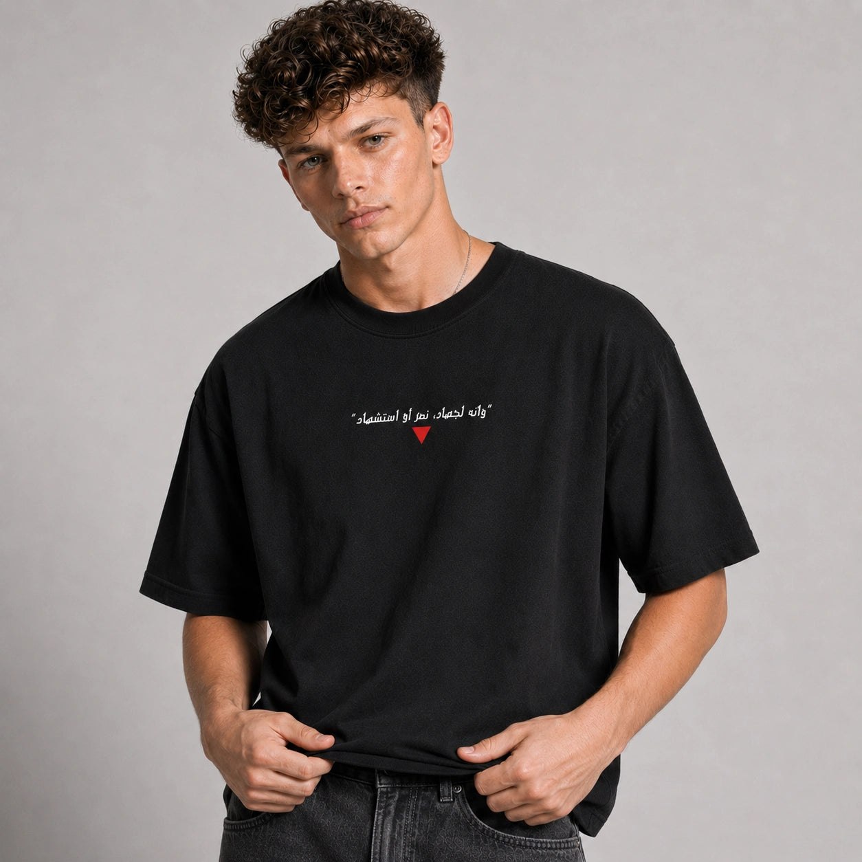 Man wearing a black t-shirt with a red heart design on a gray background