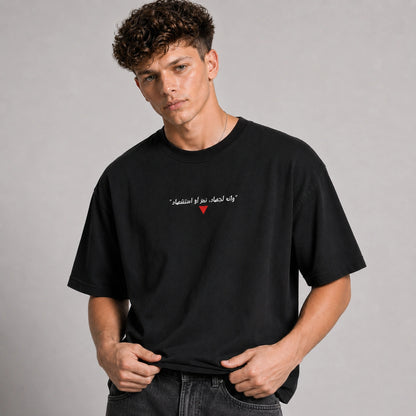 Man wearing a black t-shirt with a red heart design on a gray background