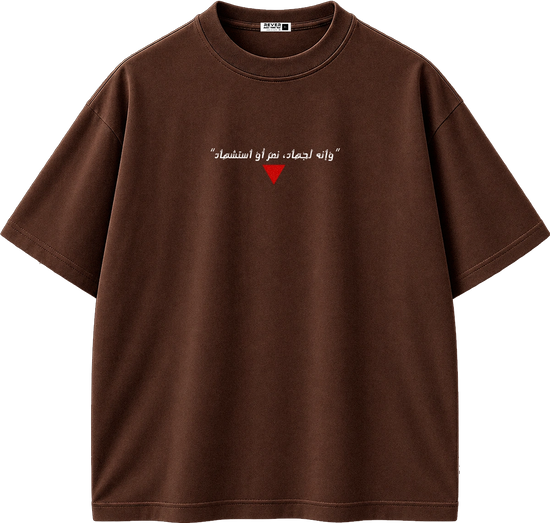 A brown short-sleeve crewneck t-shirt with white Arabic text and a small red heart graphic on the chest, displayed against a solid white background.