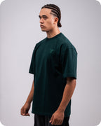 REVER dark-green oversized plain t-shirt side profile highlighting loose fit and minimal cut.