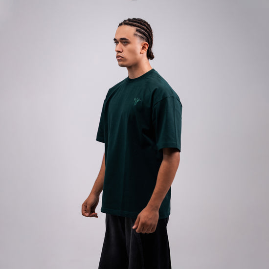 REVER dark-green oversized plain t-shirt side profile highlighting loose fit and minimal cut.