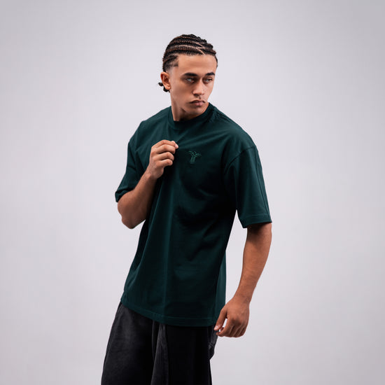 REVER dark-green oversized plain t-shirt side profile highlighting loose fit and minimal cut.
