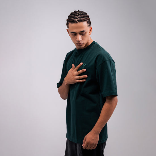 REVER dark-green oversized plain t-shirt side profile highlighting loose fit and minimal cut.