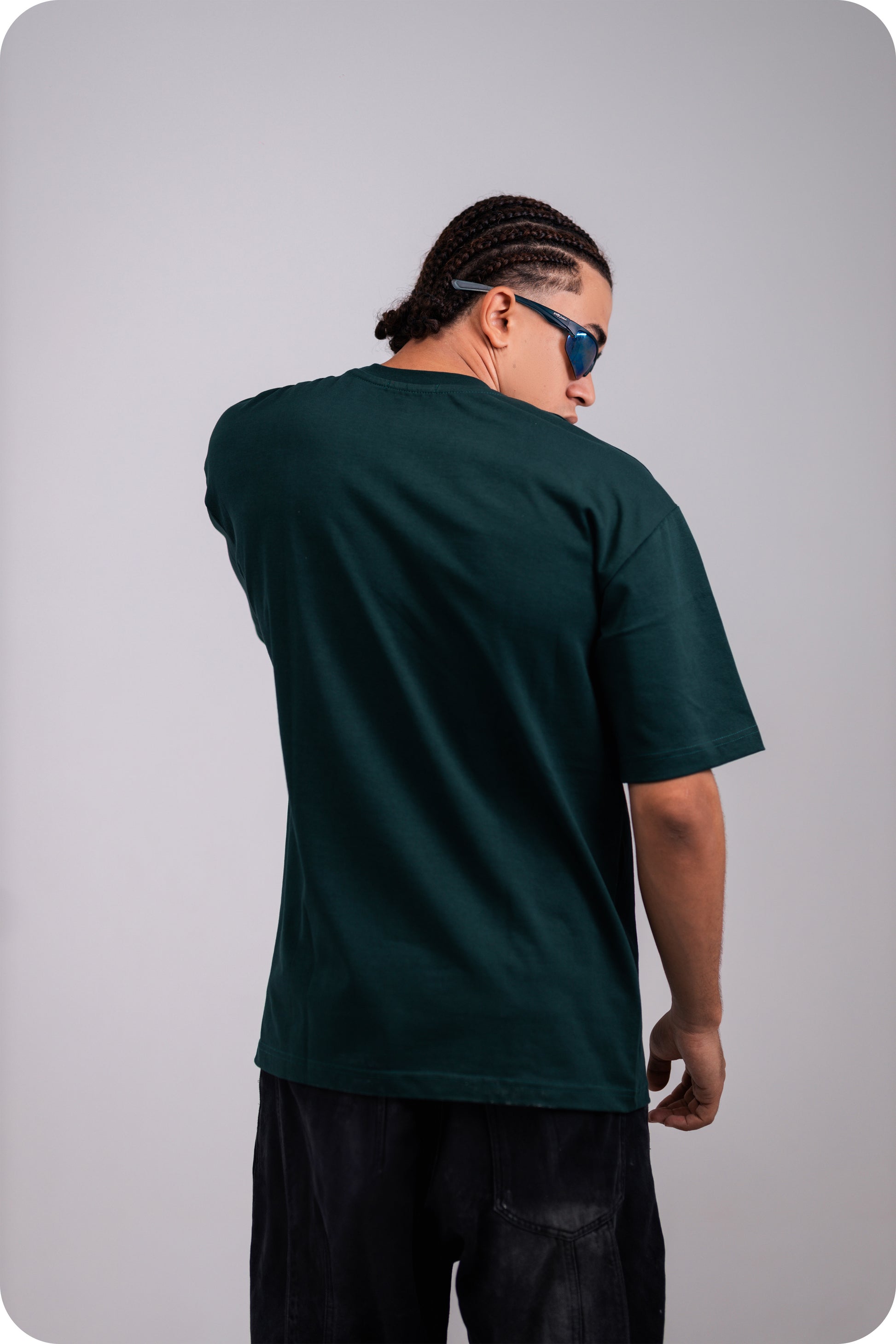 REVER dark-green oversized plain t-shirt side profile highlighting loose fit and minimal cut.