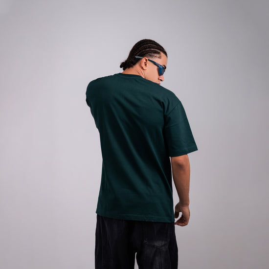REVER dark-green oversized plain t-shirt side profile highlighting loose fit and minimal cut.