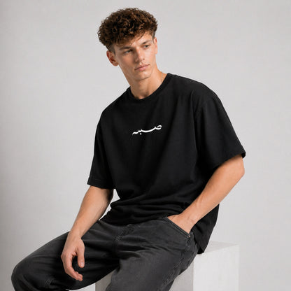 Person wearing a black t-shirt with white text on a gray background